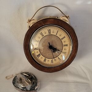 novelty clock-shaped‎ handbag that features a real, working quartz clock face.